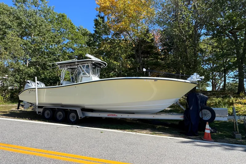  Yacht Photos Pics 2007 Yellowfin 34 Offshore boat on trailer, parked roadside with trees in background.