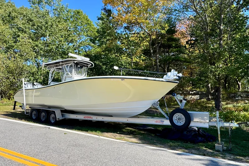  Yacht Photos Pics 2007 Yellowfin 34 Offshore boat on trailer, parked by a wooded area.