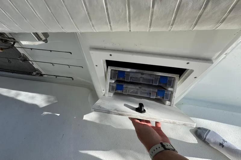  Yacht Photos Pics 2007 Yellowfin 34 Offshore boat storage compartment with tackle boxes and fishing rods.