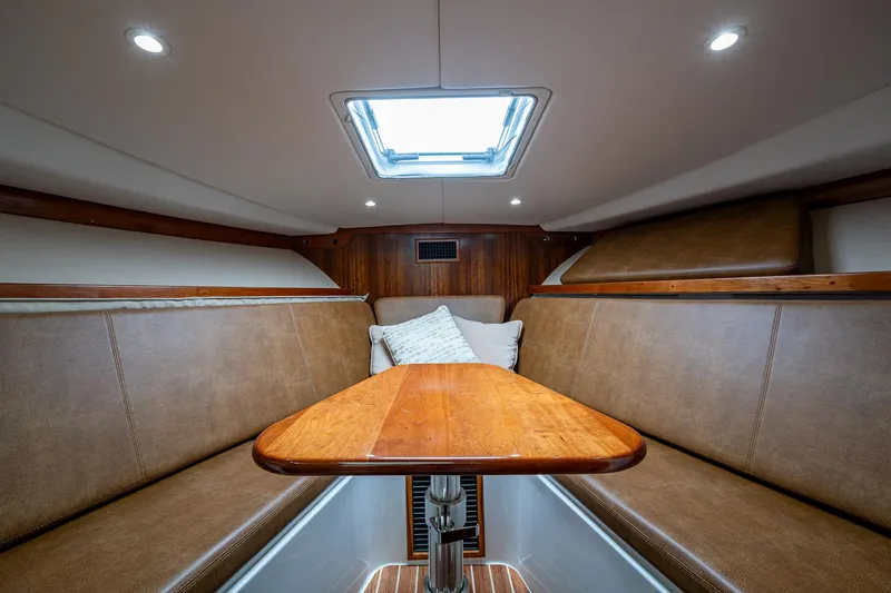 Seaclusion Yacht Photos Pics 2018 Albemarle 290 Express Fisherman cabin interior with wood table and cushioned seating.