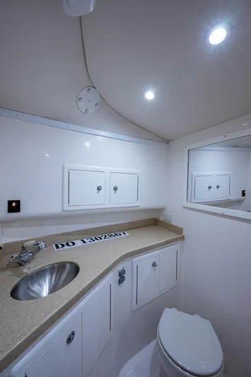 Seaclusion Yacht Photos Pics 2018 Albemarle 290 Express Fisherman bathroom with sink, toilet, and storage cabinets.