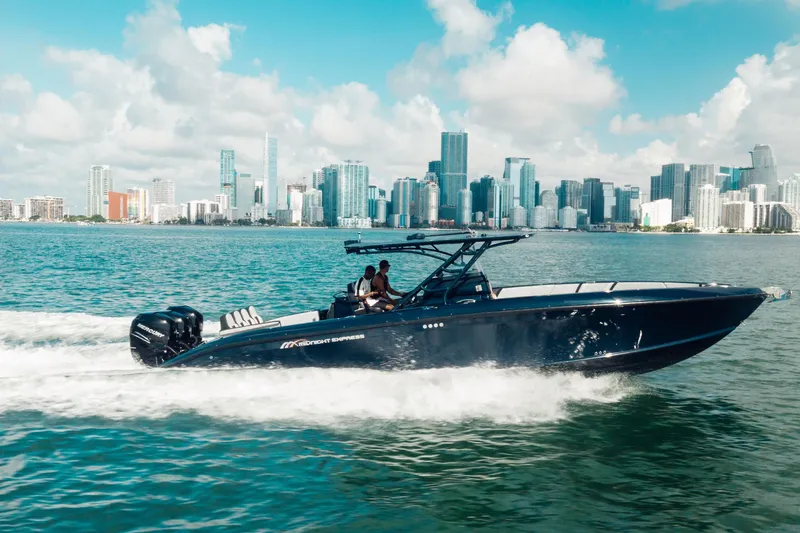 Opal Yacht Photos Pics 2014 Midnight Express 37’ Open boat cruising near city skyline on a sunny day.