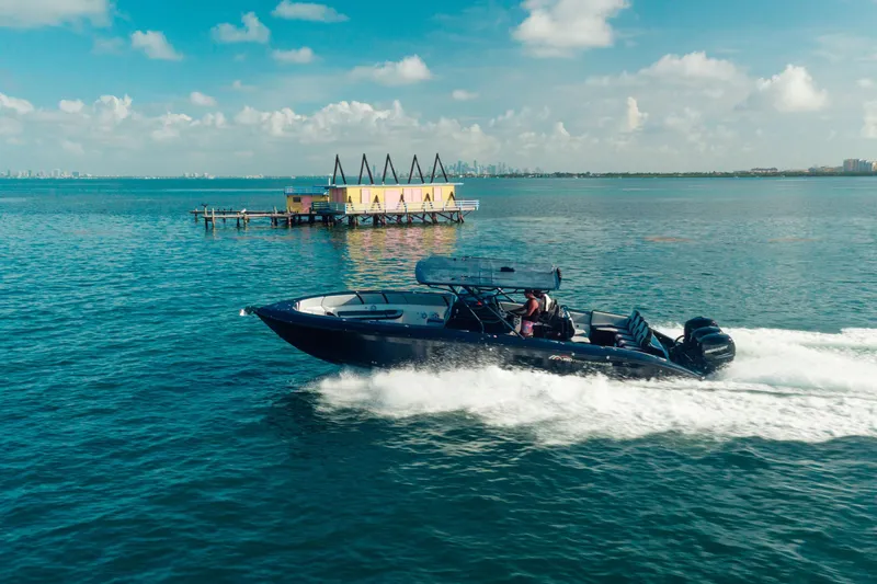 Opal Yacht Photos Pics 2014 Midnight Express 37’ Open boat cruising on blue ocean near a colorful dock.