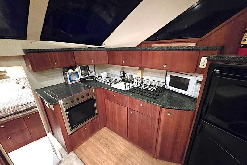  Yacht Photos Pics 2000 Silverton 392 Motor Yacht kitchen with wood cabinets, stove, microwave, and sink.