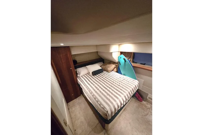  Yacht Photos Pics Cozy bedroom in 2000 Silverton 392 Motor Yacht with striped bedding and surfboard.