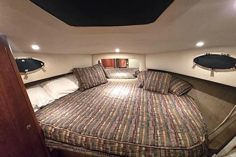  Yacht Photos Pics Cozy bedroom interior of 2000 Silverton 392 Motor Yacht with patterned bedding and soft lighting.