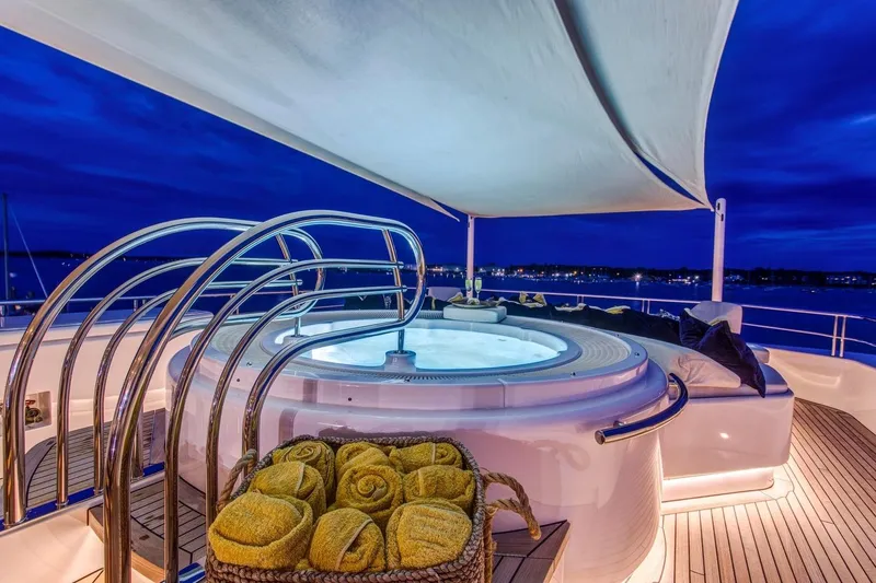 Amica Mea Yacht Photos Pics Luxurious Hakvoort Custom 2004 yacht with illuminated jacuzzi and towels at sunset.