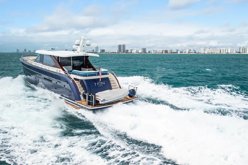 Tribu Yacht Photos Pics Steeler 60 S Performance yacht cruising in open water, city skyline in background, 2021 model.