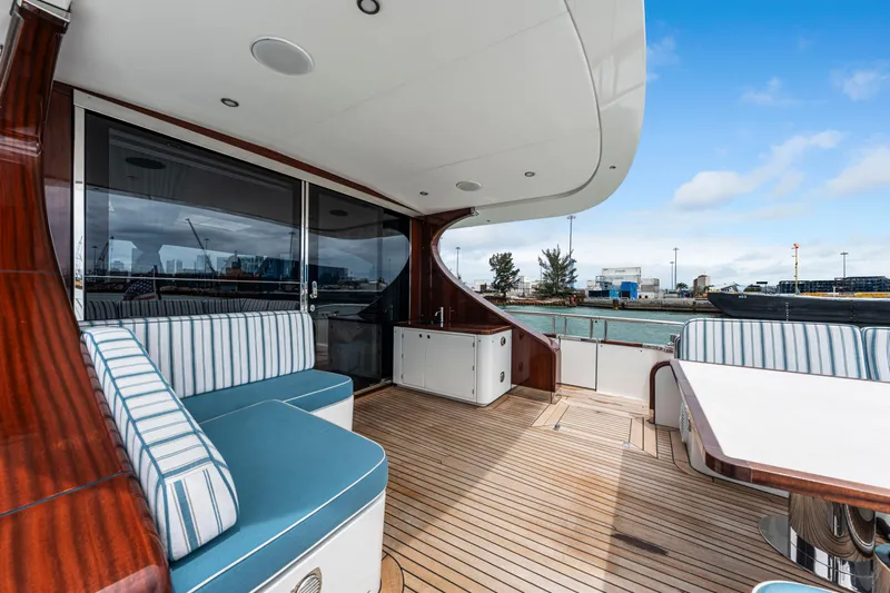 Tribu Yacht Photos Pics Luxurious 2021 Steeler 60 S Performance yacht with elegant deck seating and scenic harbor view.