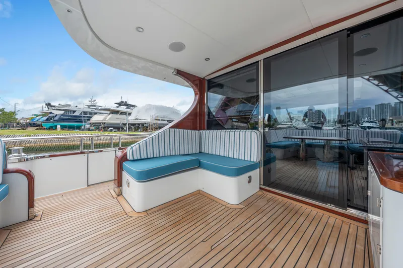 Tribu Yacht Photos Pics 2021 Steeler 60 S Performance yacht deck with seating, docked at marina.