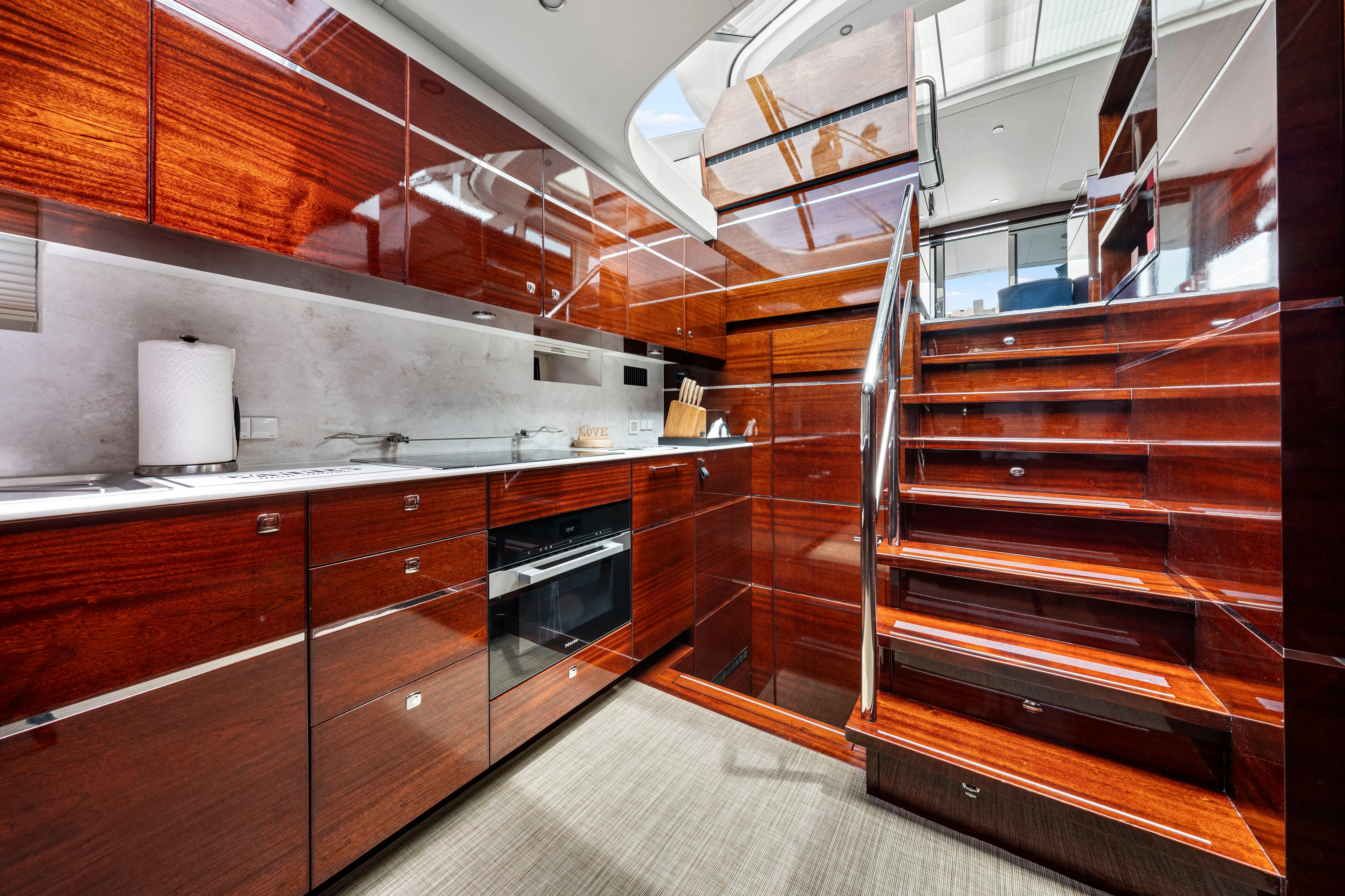 Tribu Yacht Photos Pics Luxurious kitchen interior of 2021 Steeler 60 S Performance yacht with wooden cabinetry and modern appliances.