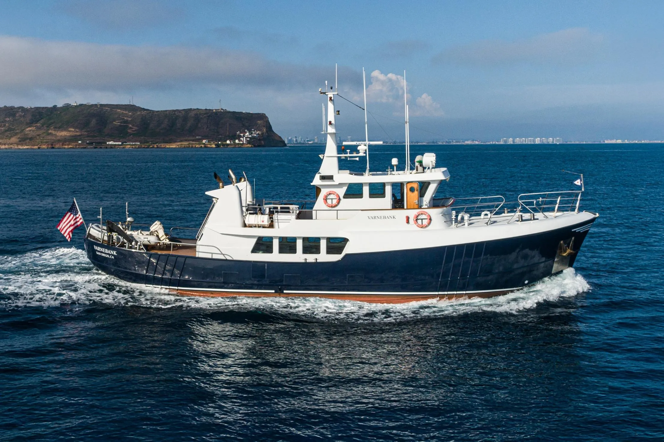 1965 Van der Molen Custom yacht cruising near a coastal landscape.