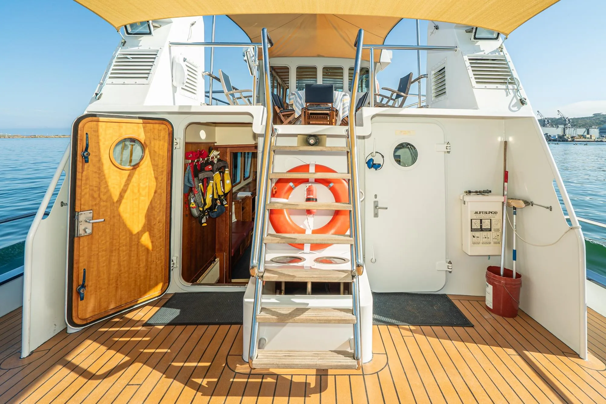 1965 Van der Molen Custom yacht deck with wooden door, life preserver, and safety equipment.