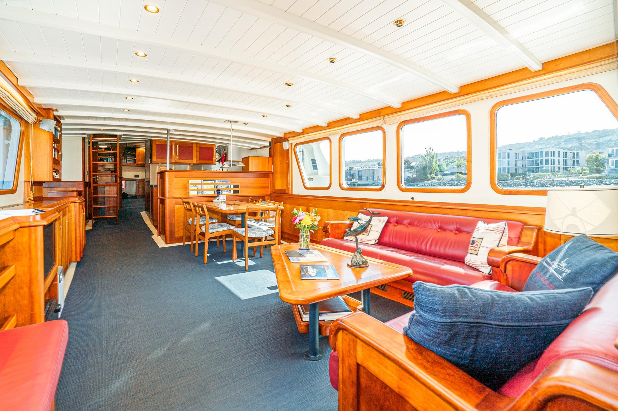 Luxurious interior of 1965 Van der Molen Custom yacht with elegant wood furnishings and red seating.