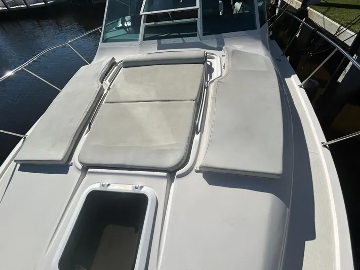 Reel Estate Yacht Photos Pics 1998 Tiara Yachts 3500 Express boat deck with cushioned seating and open hatch.