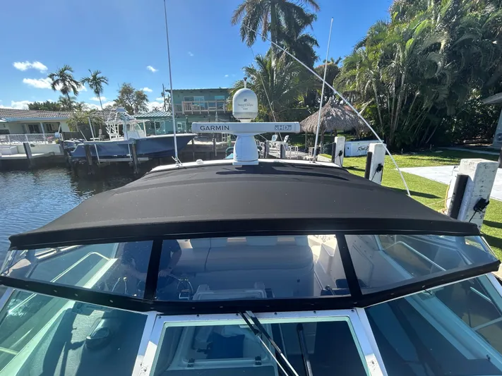 Reel Estate Yacht Photos Pics 1998 Tiara Yachts 3500 Express docked, featuring a sleek black canopy and Garmin radar.