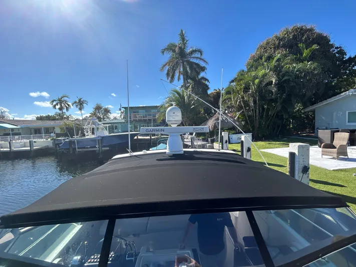 Reel Estate Yacht Photos Pics 1998 Tiara Yachts 3500 Express docked, sunny day, palm trees, waterfront view.