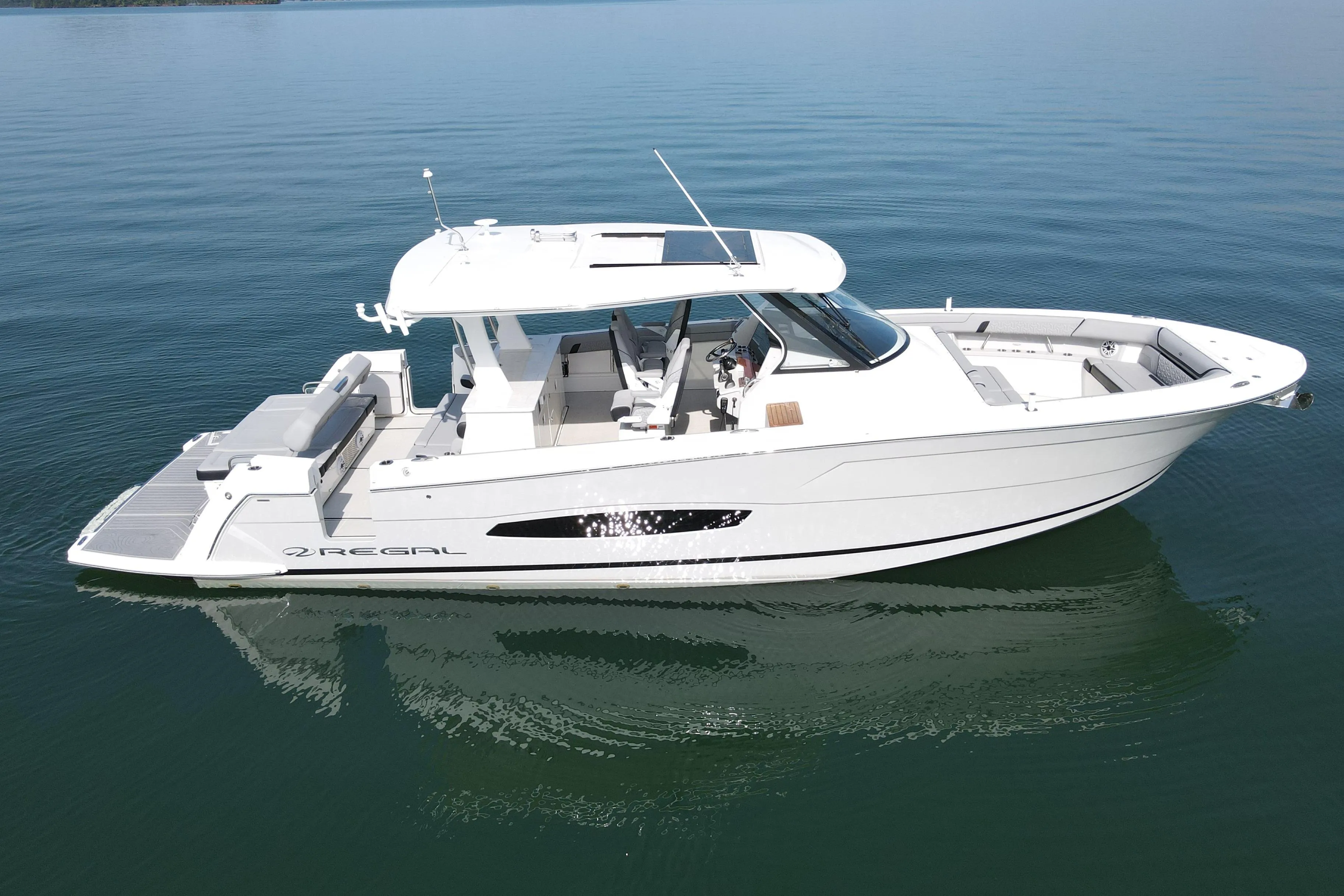 2024 Regal 38 Surf boat on calm water, showcasing sleek design and spacious deck.