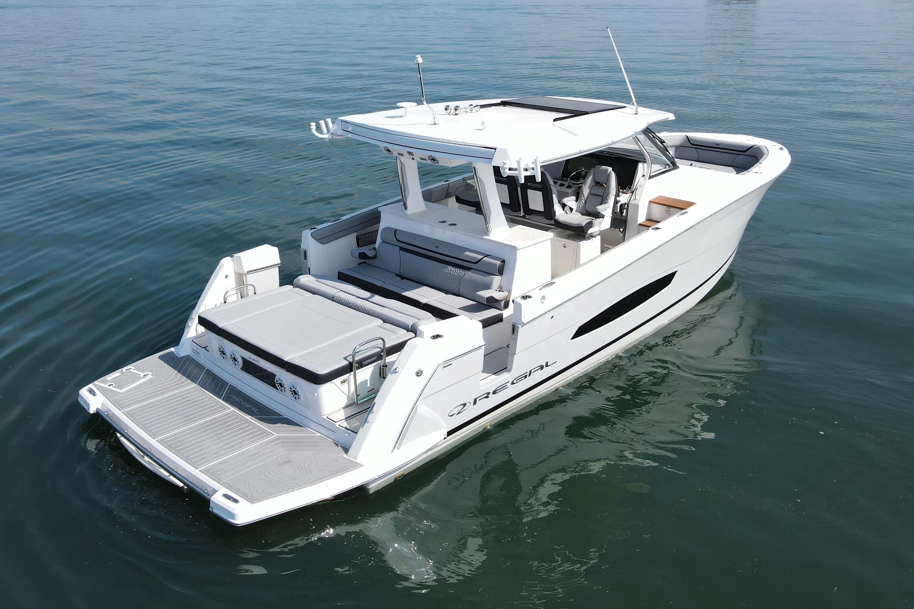 2024 Regal 38 Surf boat on calm water, showcasing sleek design and spacious deck.