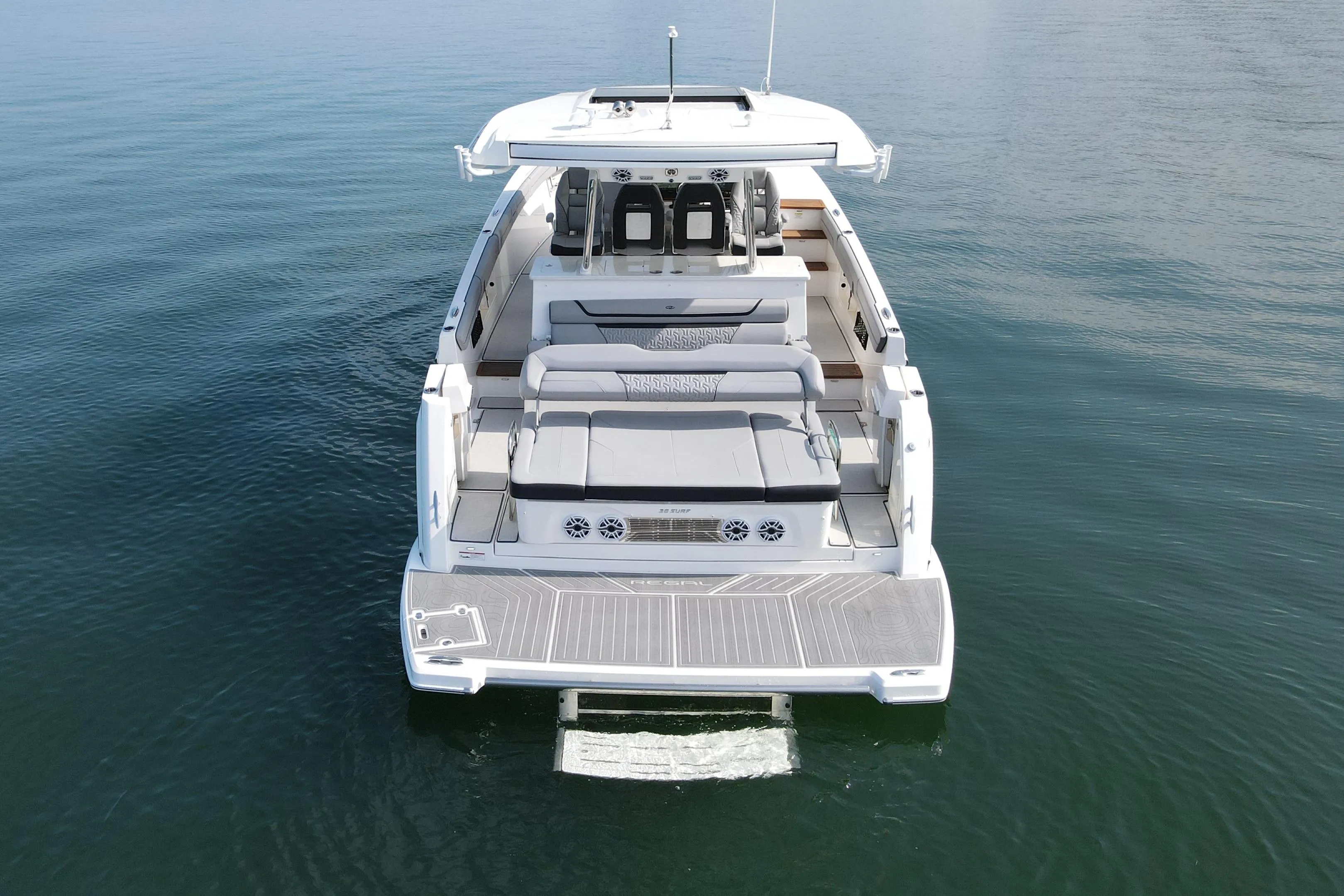 2024 Regal 38 Surf boat on calm water, rear view showcasing spacious deck.