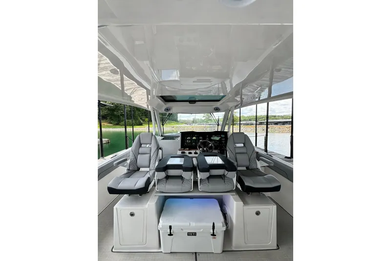 It's Good Yacht Photos Pics 2024 Regal 38 Surf boat interior with modern seating and helm, docked by a scenic lake.