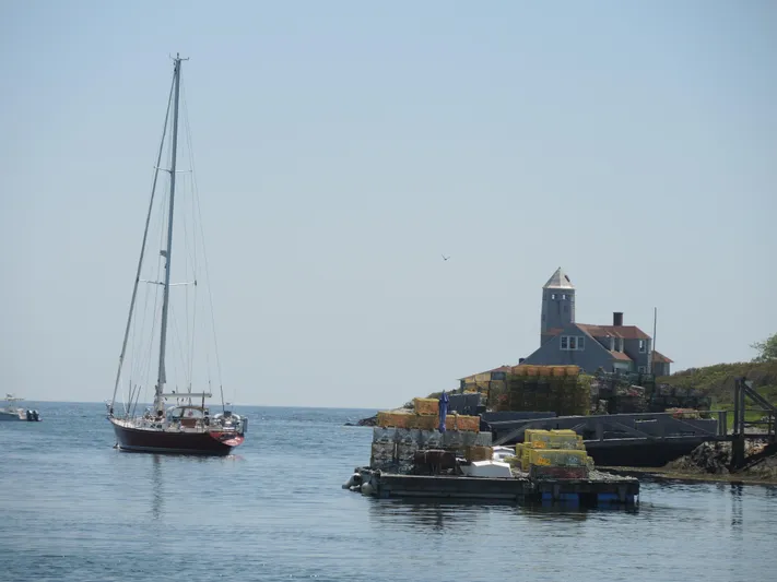 Helianthus Yacht Photos Pics Sailboat Hinckley SW 42, 1985, near coastal building and lobster traps on a sunny day.