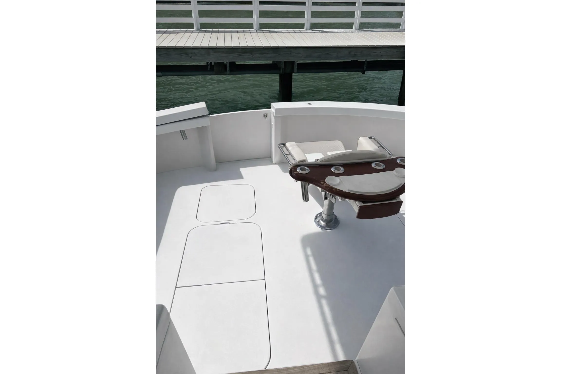 1999 Post 50 boat deck with fishing chair, docked by wooden pier.