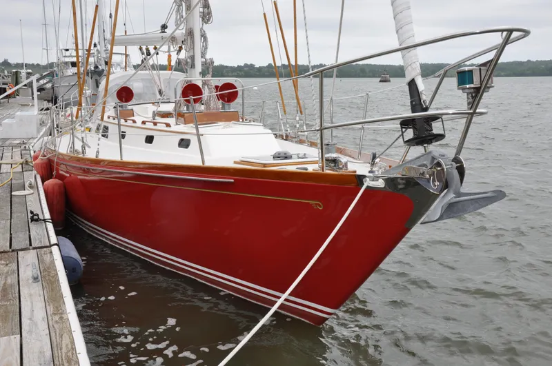 Helianthus Yacht Photos Pics 1985 Hinckley SW 42 sailboat with a red hull docked at a marina.