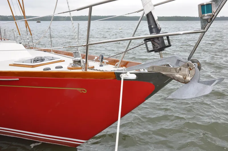 Helianthus Yacht Photos Pics 1985 Hinckley SW 42 sailboat with red hull anchored in water.