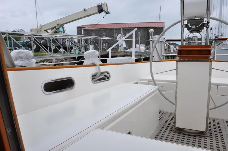 Helianthus Yacht Photos Pics 1985 Hinckley SW 42 sailboat cockpit with steering wheel and dock background.