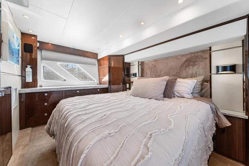Sunline Yacht Photos Pics Luxurious bedroom interior of a 2007 Marquis 55 LS yacht with elegant bedding and wood accents.