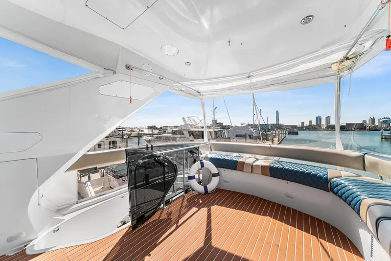 Sunline Yacht Photos Pics Luxurious 2007 Marquis 55 LS yacht deck with seating, overlooking marina and city skyline.