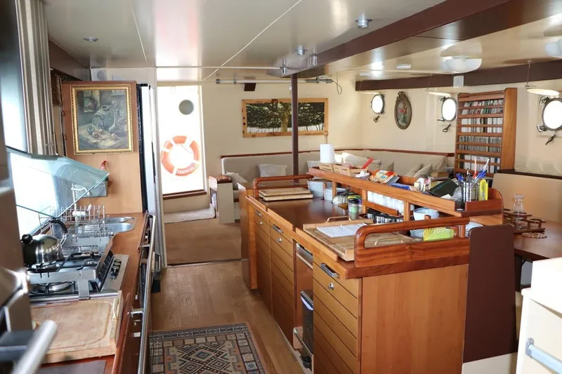 Zeewoelf Yacht Photos Pics Interior of 1963 Custom Mr. de Boot yacht with wooden kitchen and cozy seating area.