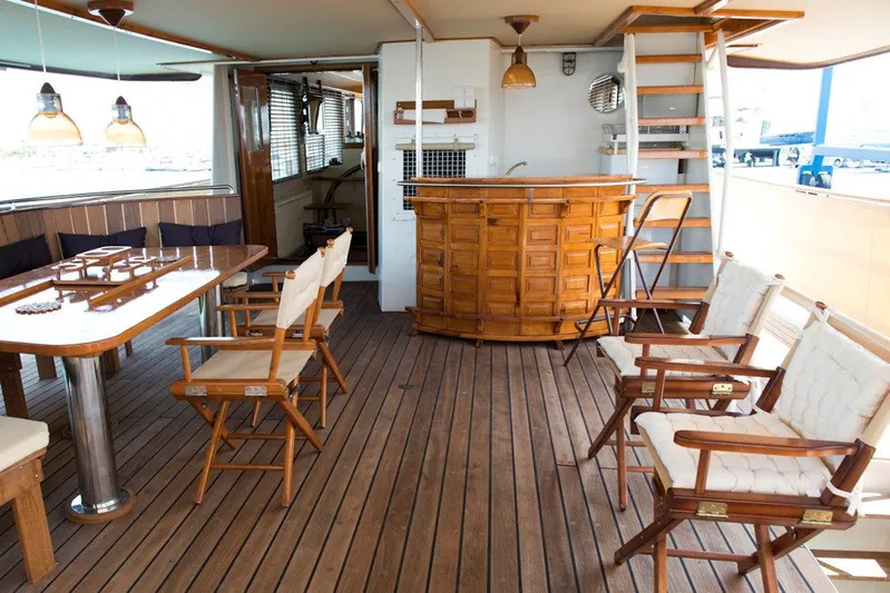 Zeewoelf Yacht Photos Pics Luxurious 1963 custom yacht interior with wooden deck, bar, and seating area.