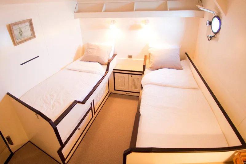 Zeewoelf Yacht Photos Pics Cozy twin cabin interior on 1963 Custom Mr. de Boot boat, featuring warm lighting and nautical decor.