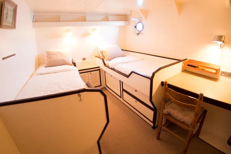 Zeewoelf Yacht Photos Pics Cozy cabin interior with twin beds, desk, and warm lighting on a 1963 Custom Mr. de Boot.