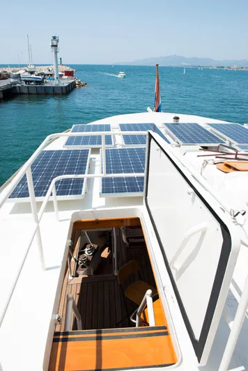 Zeewoelf Yacht Photos Pics Custom 1963 "mr. de Boot" yacht with solar panels, open hatch, docked in a sunny harbor.