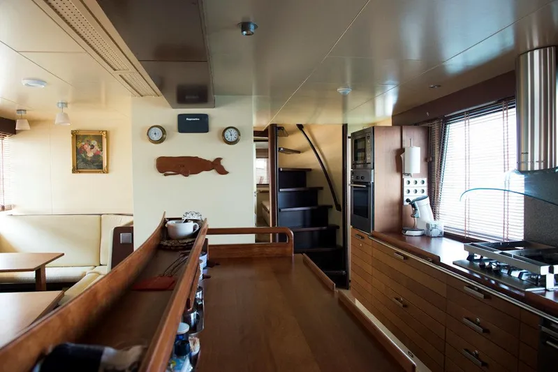 Zeewoelf Yacht Photos Pics Interior of a 1963 Custom Mr. de Boot yacht with wooden furnishings and modern kitchen.