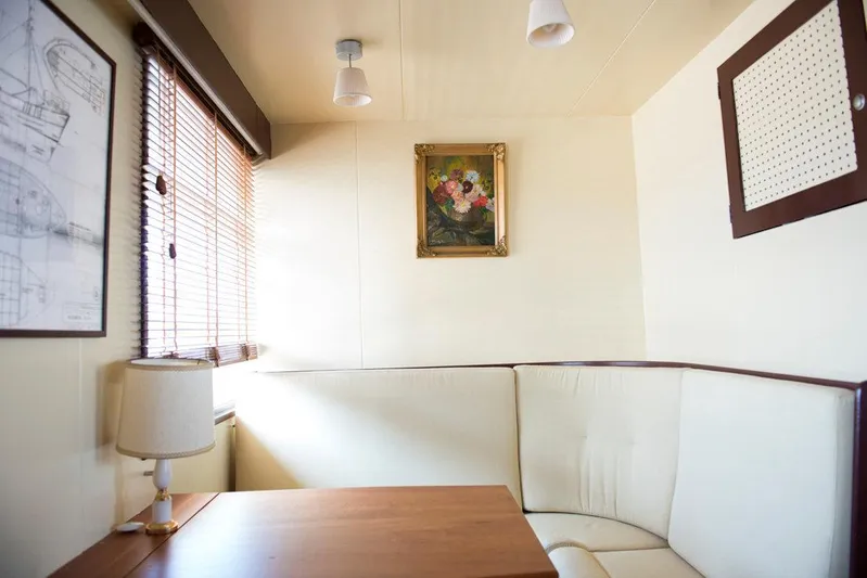 Zeewoelf Yacht Photos Pics Cozy 1963 Custom "mr. de Boot" cabin with corner seating, wooden table, and wall art.