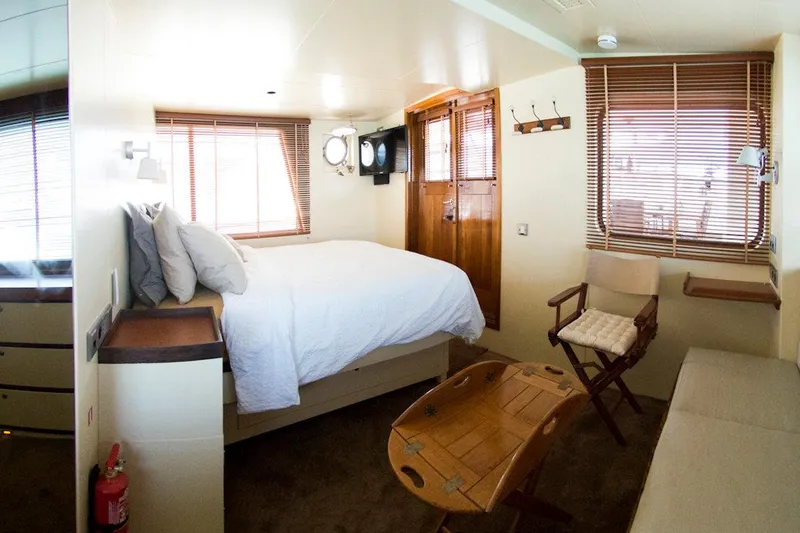 Zeewoelf Yacht Photos Pics Cozy cabin interior on 1963 Custom mr. de Boot boat with bed, chair, and wooden accents.
