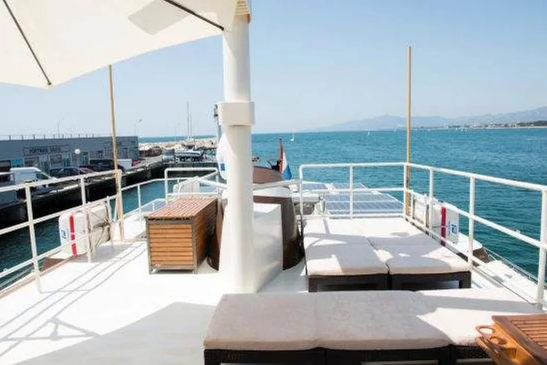 Zeewoelf Yacht Photos Pics Deck view of 1963 Custom Mr. de Boot yacht, featuring sun loungers and ocean backdrop.