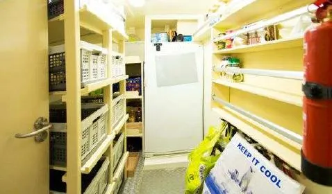 Zeewoelf Yacht Photos Pics Storage room with shelves, baskets, a refrigerator, and a fire extinguisher. Custom "mr. de Boot" 1963.