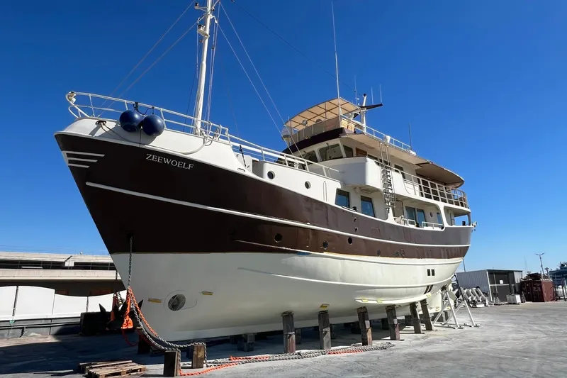 Zeewoelf Yacht Photos Pics Custom 1963 "mr. de Boot" yacht on dry dock under clear blue sky.