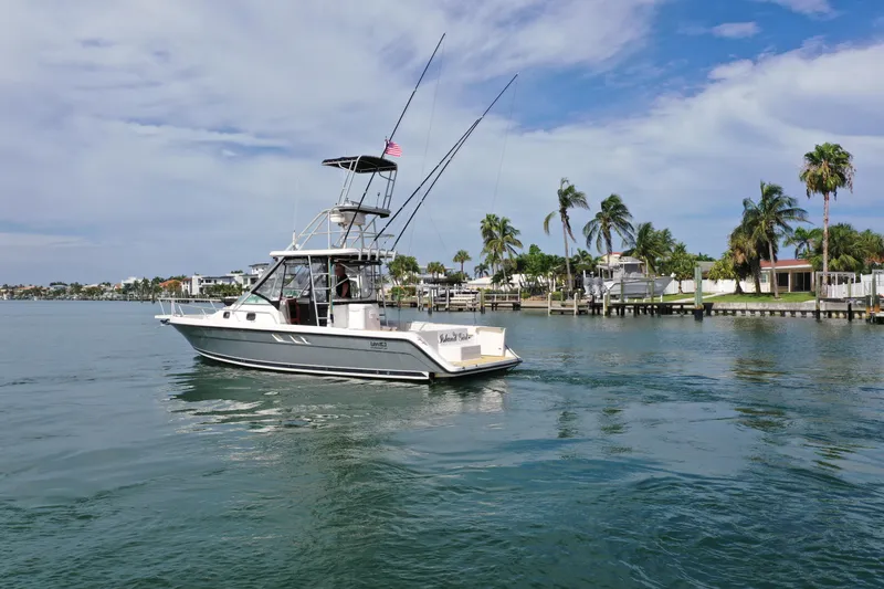 Island Girl Yacht Photos Pics 1992 Luhrs 300 Tournament boat cruising on a sunny day near palm-lined shore.