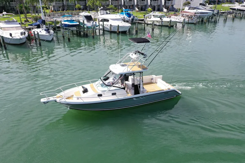 Island Girl Yacht Photos Pics 1992 Luhrs 300 Tournament boat cruising in a marina with docked vessels nearby.