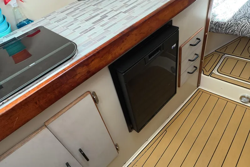 Island Girl Yacht Photos Pics Interior of a 1992 Luhrs 300 Tournament boat with kitchenette and wood flooring.