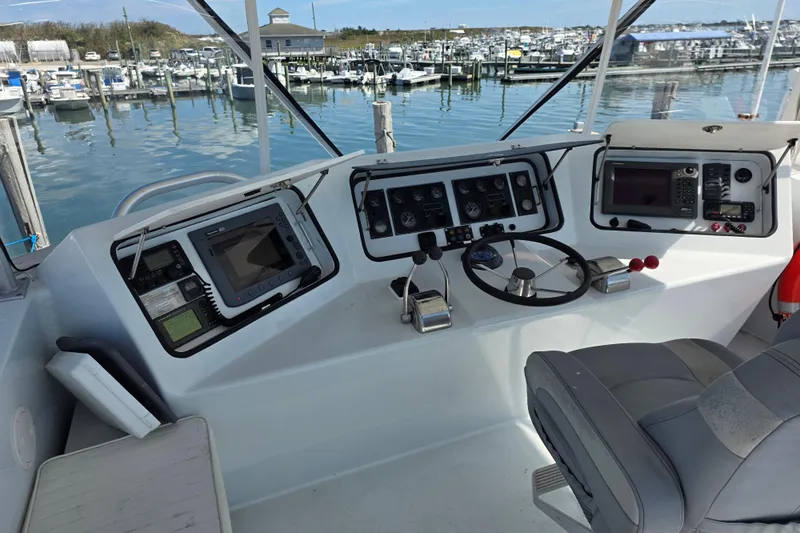  Yacht Photos Pics Helm of 2000 JM Custom 42 boat with navigation equipment and marina view.