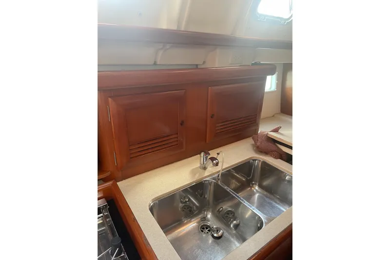 Kasoumai Yacht Photos Pics 2007 Beneteau 423 yacht kitchen with wooden cabinets and stainless steel sink.