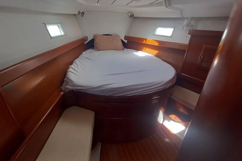 Kasoumai Yacht Photos Pics Cozy cabin interior of 2007 Beneteau 423 sailboat with wooden finish and round bed.