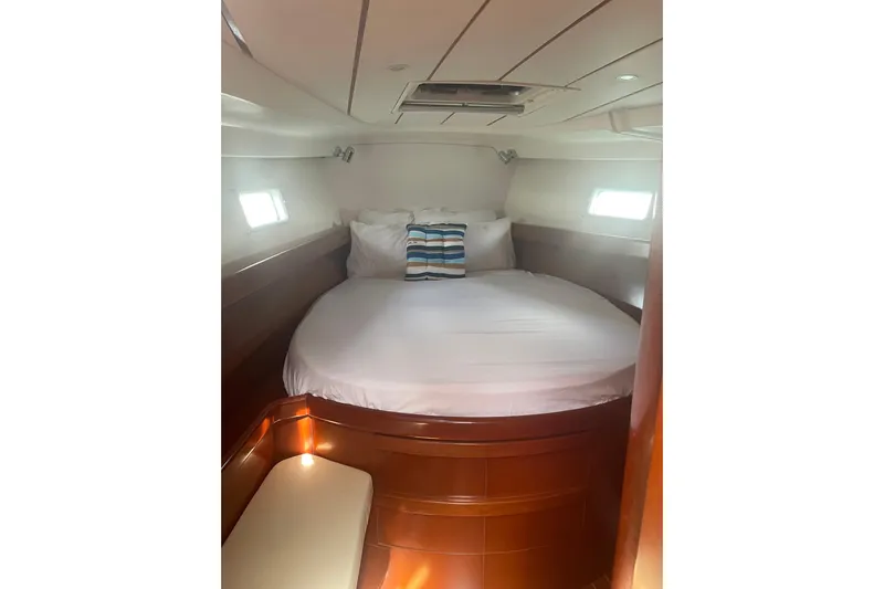 Kasoumai Yacht Photos Pics Cozy cabin interior of 2007 Beneteau 423 yacht with round bed and porthole windows.